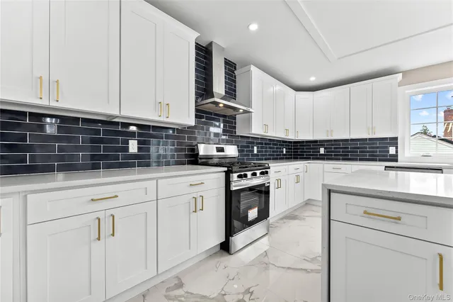 a kitchen with granite countertop white cabinets and stainless steel appliances