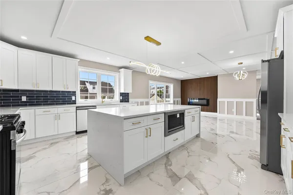 a large kitchen with stainless steel appliances and white cabinets