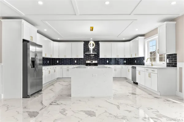 a kitchen with stainless steel appliances kitchen island granite countertop a refrigerator a stove a sink and a granite counter tops