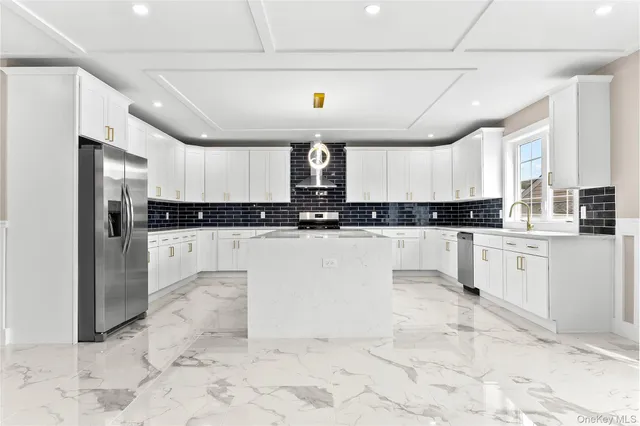 a kitchen with stainless steel appliances kitchen island granite countertop a refrigerator a stove a sink and a granite counter tops