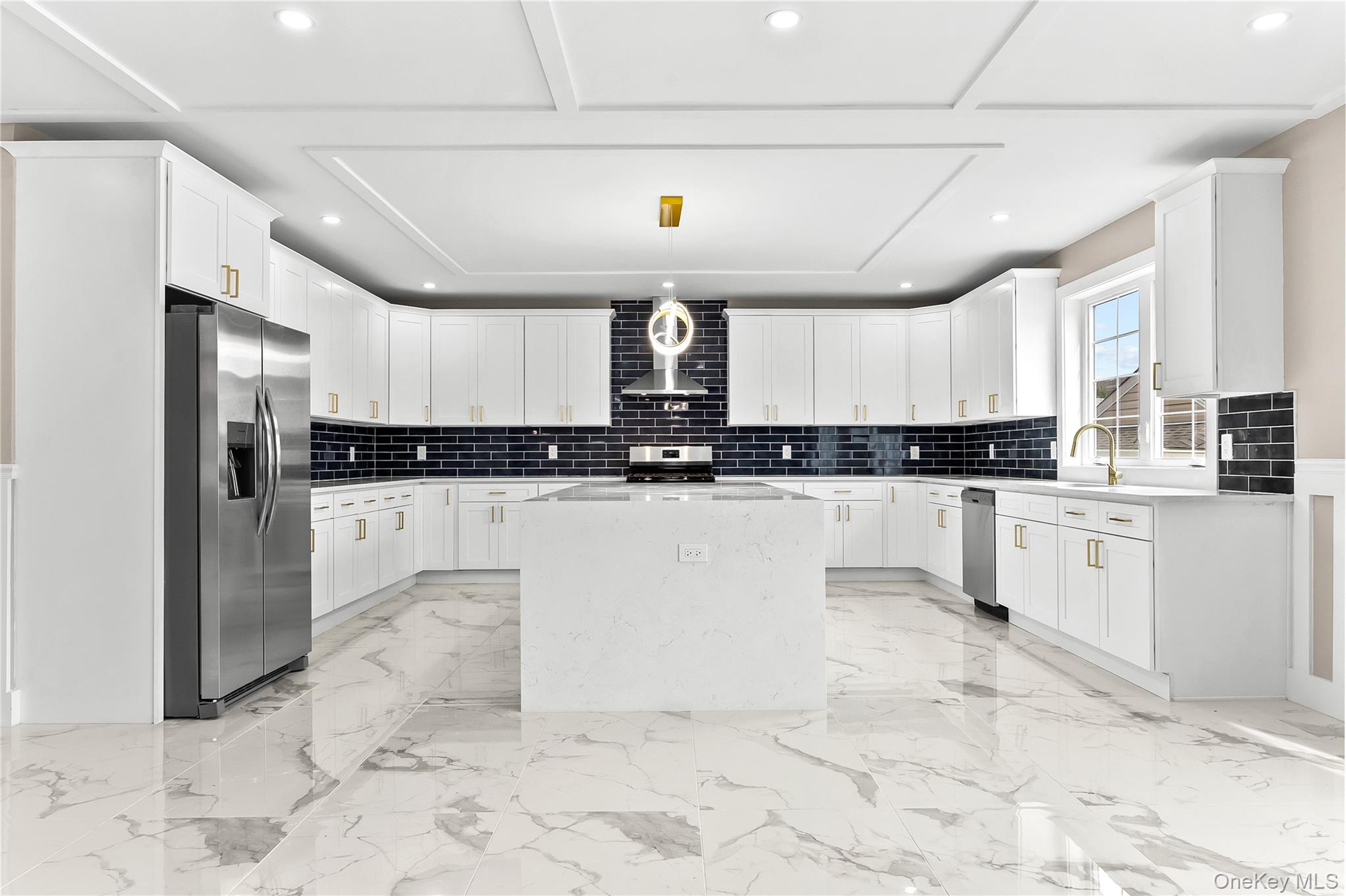 311 Lyon Street Valley Stream, NY 11580 - Photo 17 of 45 a kitchen with stainless steel appliances kitchen island granite countertop a refrigerator a stove a sink and a granite counter tops