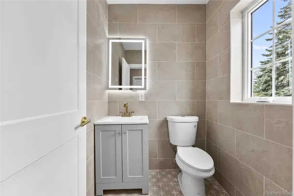 a bathroom with a toilet sink and mirror