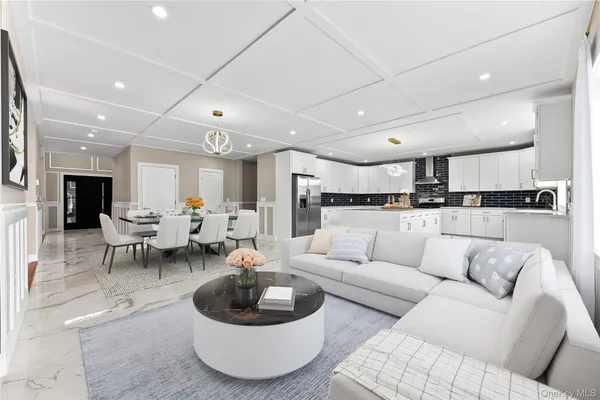 a living room with furniture and a view of kitchen