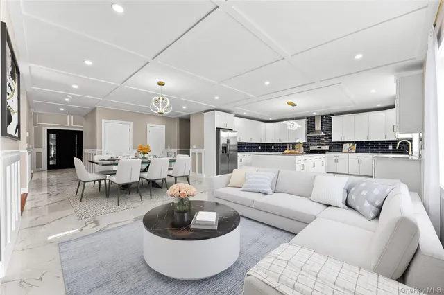 a living room with furniture and a view of kitchen