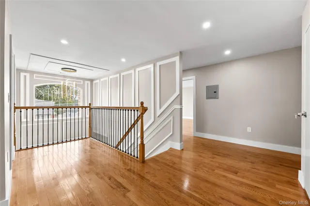 a view of a hallway with wooden floor and staircase