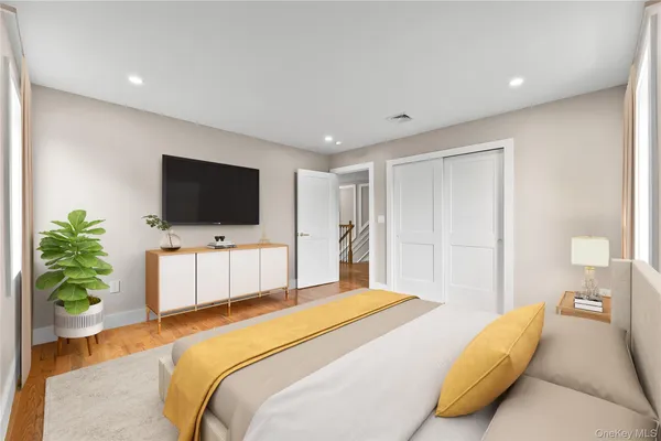 a bedroom with a large bed and a flat screen tv