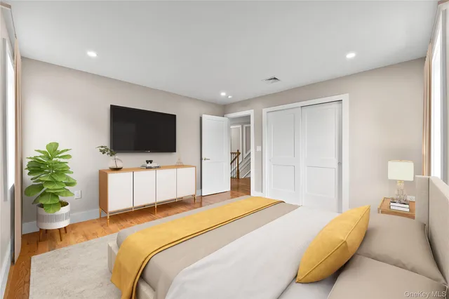 a bedroom with a large bed and a flat screen tv