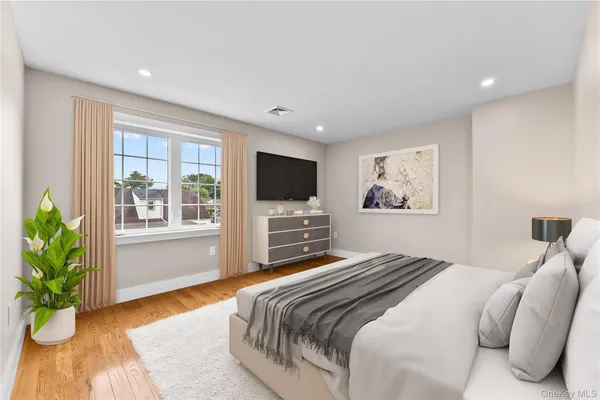 a spacious bedroom with a bed and a potted plant