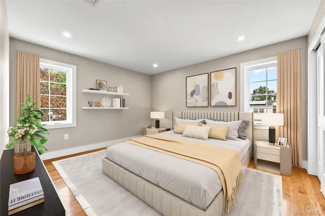 a bedroom with a bed and a flat screen tv in white walls