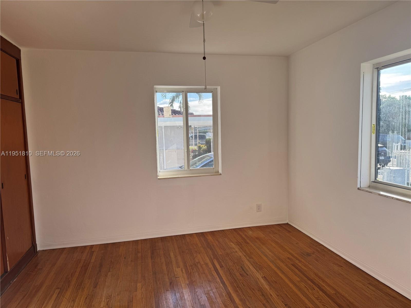 3535 Northwest 82nd Street Miami, FL 33147 - Photo 13 of 14 an empty room with wooden floor and windows