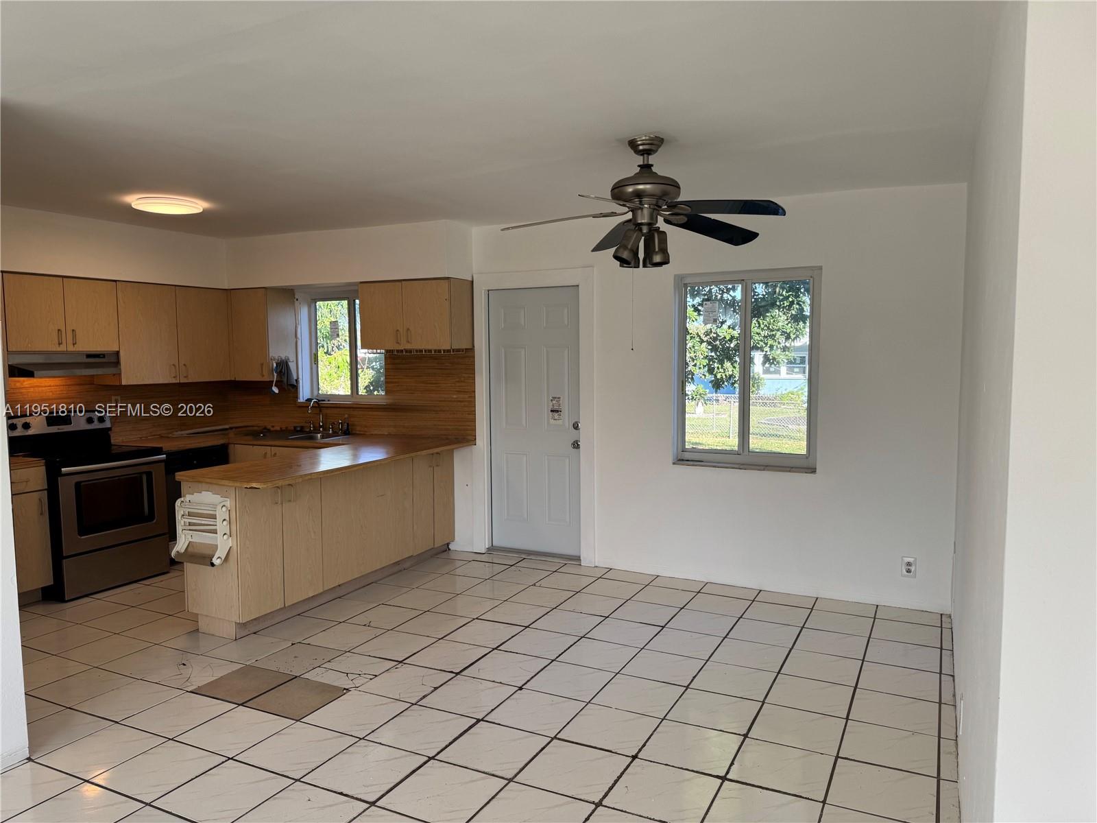 3535 Northwest 82nd Street Miami, FL 33147 - Photo 4 of 14 a kitchen with a stove a sink and a refrigerator