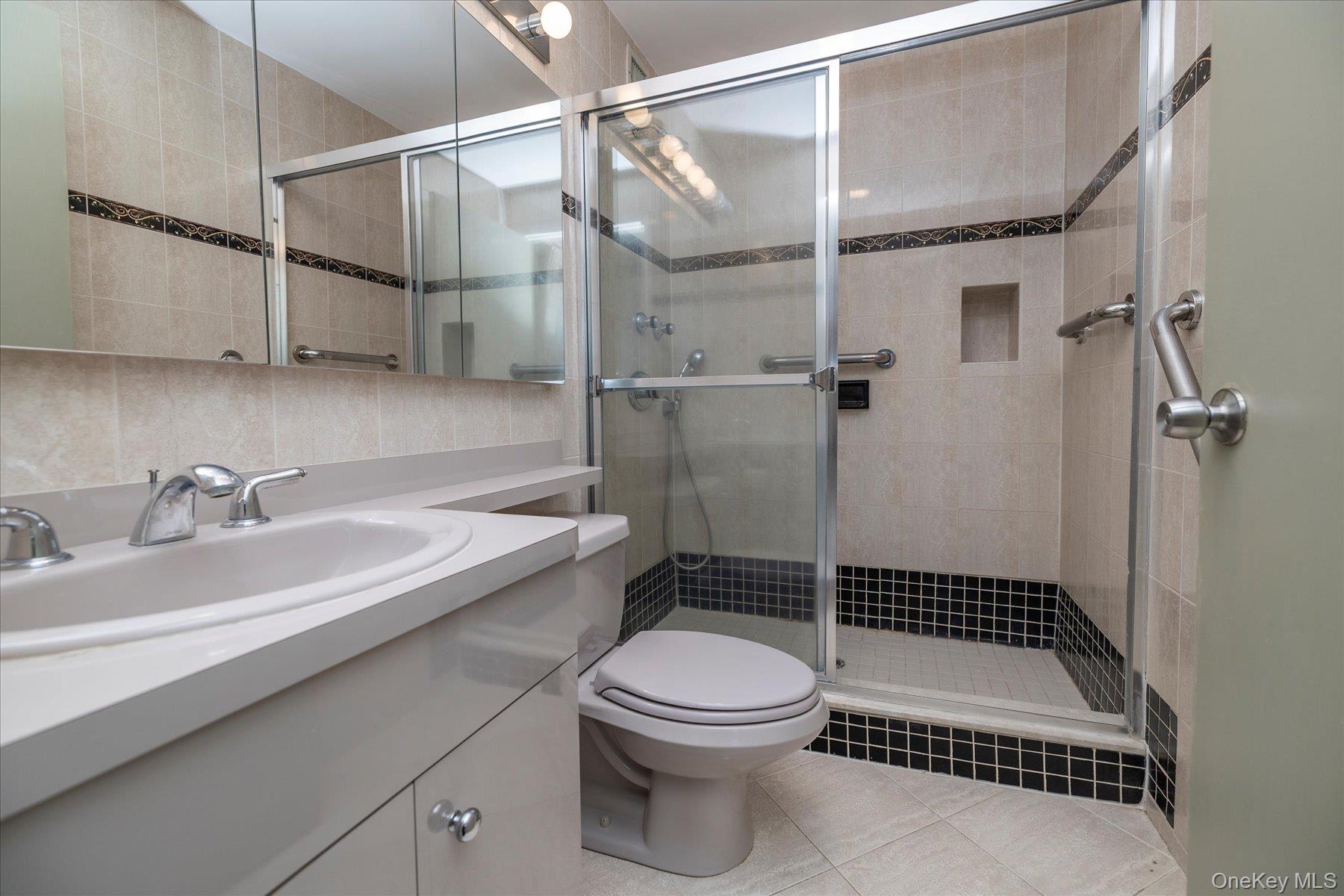 360 Shore Road, Unit 6L & 6M Long Beach, NY 11561 - Photo 21 of 28 a bathroom with a sink a toilet a mirror and shower