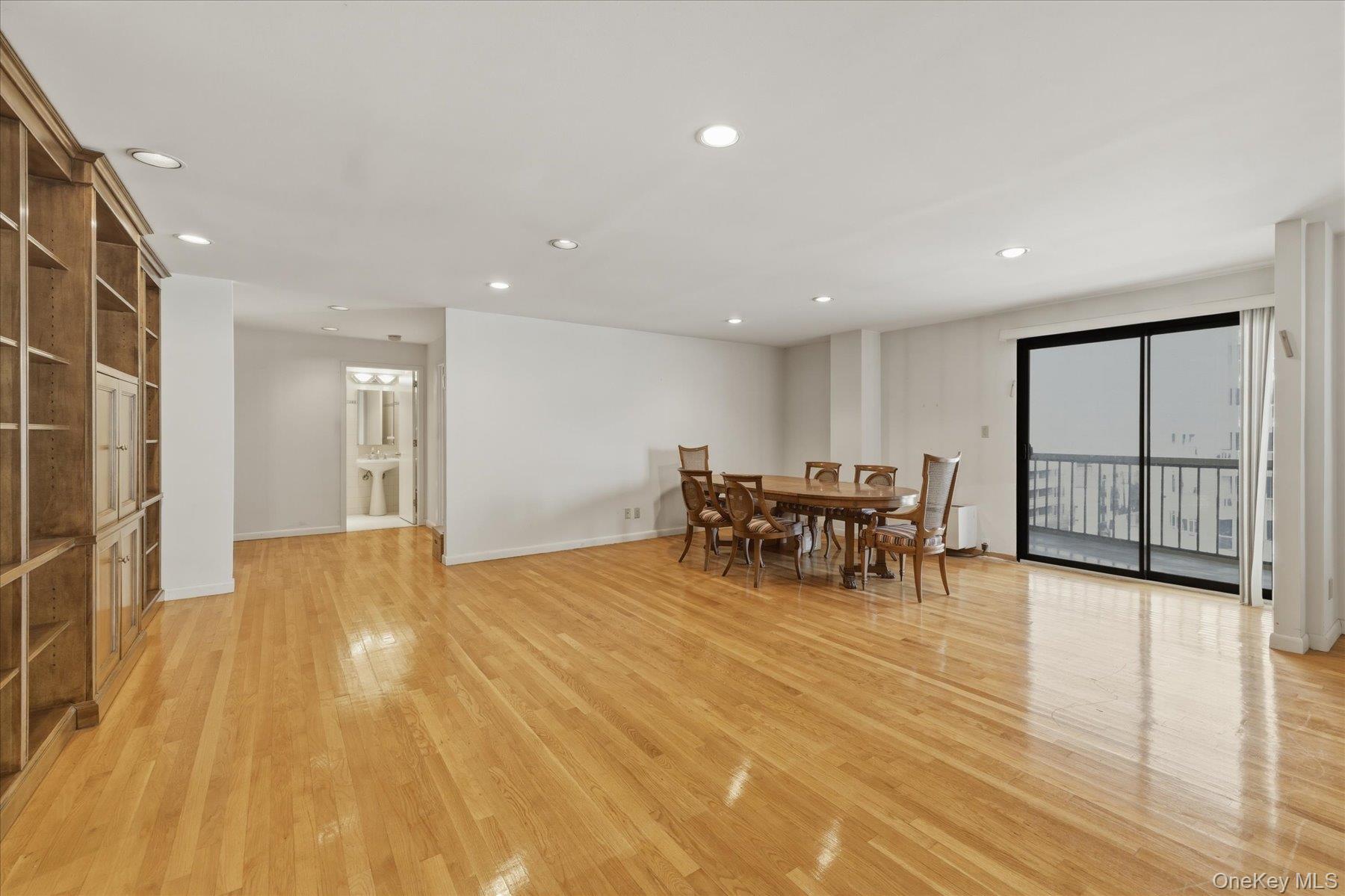 360 Shore Road, Unit 6L & 6M Long Beach, NY 11561 - Photo 9 of 28 a view of a big room with wooden floor a glass table and chairs