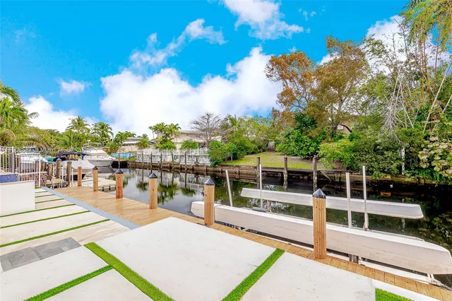 a view of a swimming pool with a lounge chair and palm trees