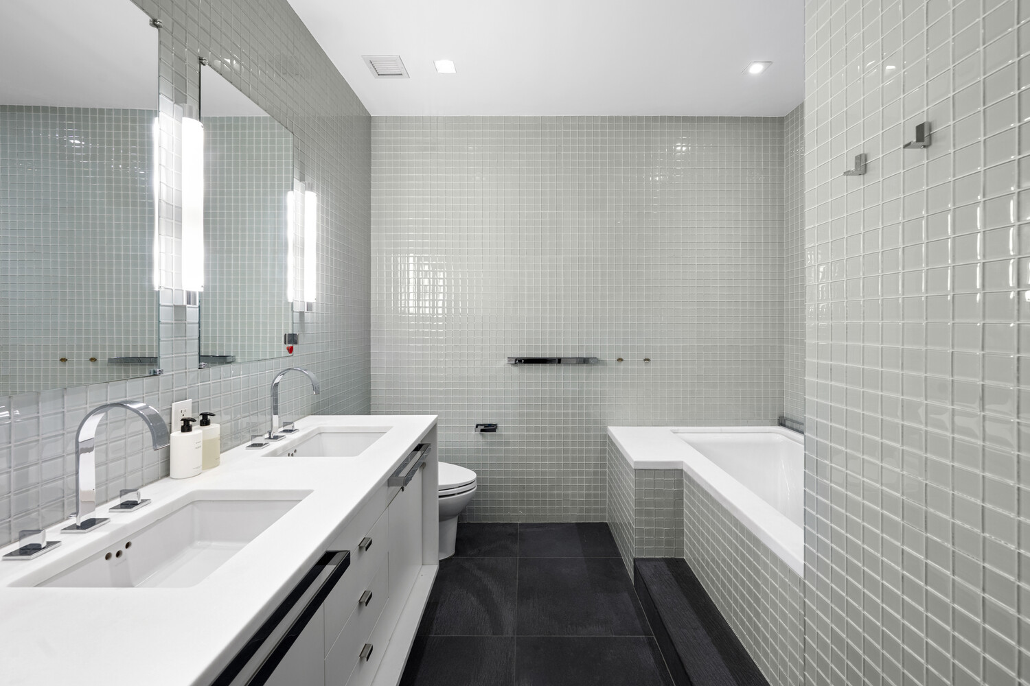 252 7th Avenue, Unit 15N Manhattan, NY 10001 - Photo 8 of 15 a bathroom with a double vanity sink a toilet and a mirror