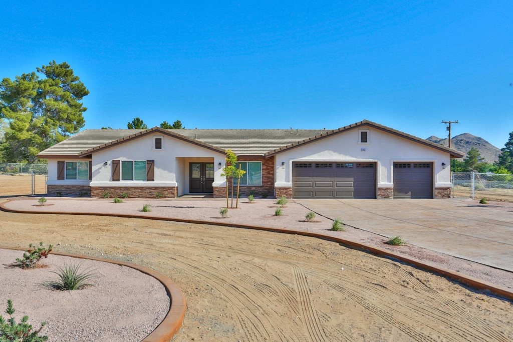 14690 Erie Road Apple Valley, CA 92307 - Photo 1 of 1 a white house with a large yard and wooden fence