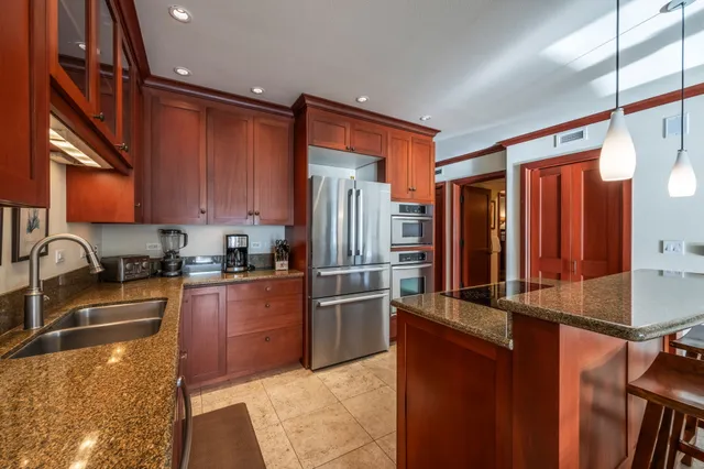 a kitchen with stainless steel appliances granite countertop a refrigerator a stove top oven a sink and dishwasher