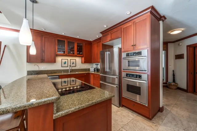 a kitchen with granite countertop a sink stove and refrigerator