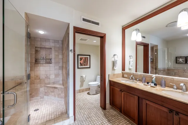 a spacious bathroom with a double vanity sink a toilet and a shower