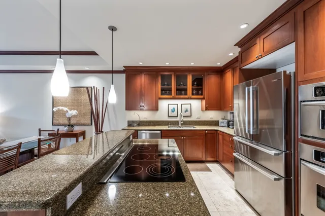 a kitchen with stainless steel appliances granite countertop a refrigerator and a stove