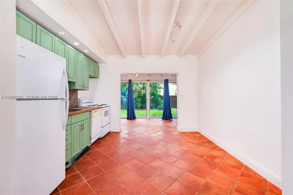 a large room with a window and a kitchen view
