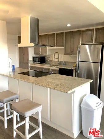 a kitchen with a sink a stove a refrigerator and white cabinets