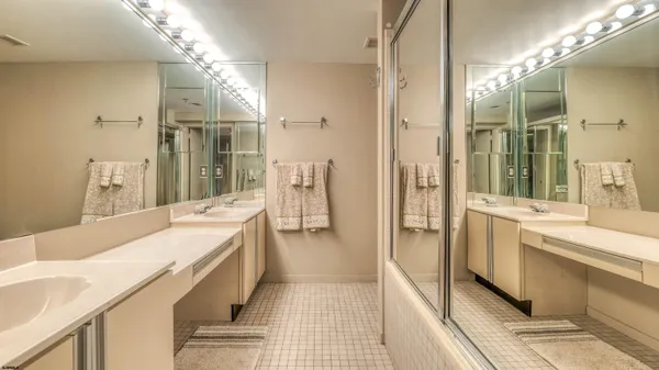 a bathroom with a double vanity sink a mirror and a shower
