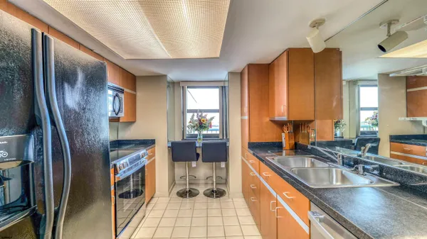 a kitchen with stainless steel appliances granite countertop a sink a stove and a refrigerator