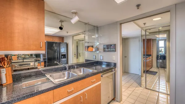 a kitchen with stainless steel appliances granite countertop a sink and a refrigerator