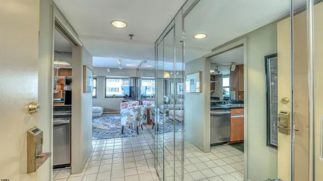 a dining hall with stainless steel appliances kitchen island granite countertop a refrigerator and a sink