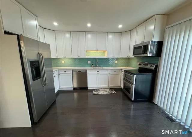 a kitchen with a sink a refrigerator a microwave and cabinets