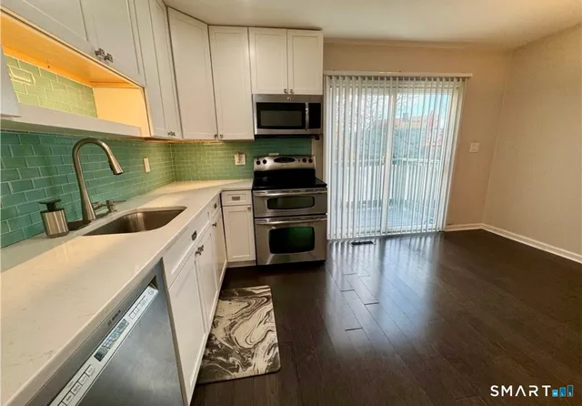 a kitchen with a sink a microwave and cabinets