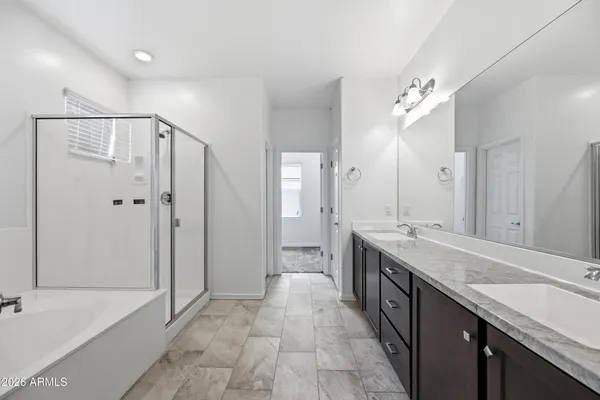 a large bathroom with a granite countertop double vanity sink mirror and shower