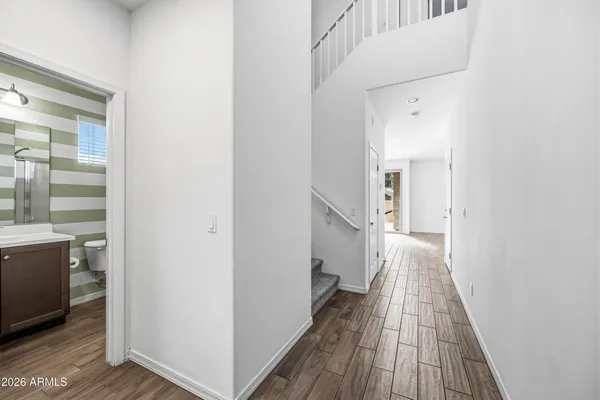 a view of a hallway with wooden floor and staircase
