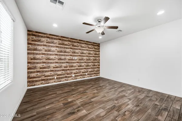 a view of an empty room with a window and wooden floor