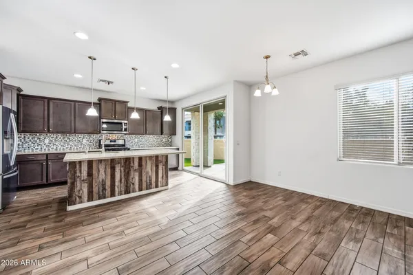 a kitchen with stainless steel appliances kitchen island granite countertop a stove a sink and a refrigerator