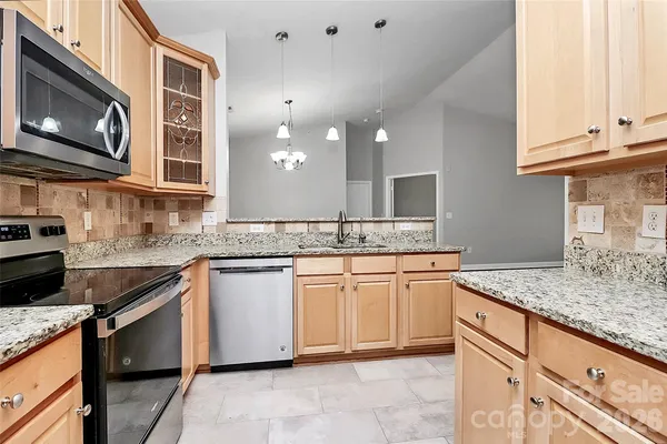 a kitchen with granite countertop cabinets stainless steel appliances and a counter space