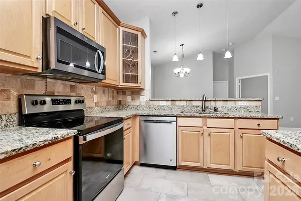 a kitchen with stainless steel appliances granite countertop a stove microwave and cabinets