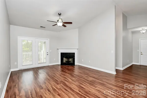 a view of empty room with wooden floor and fireplace