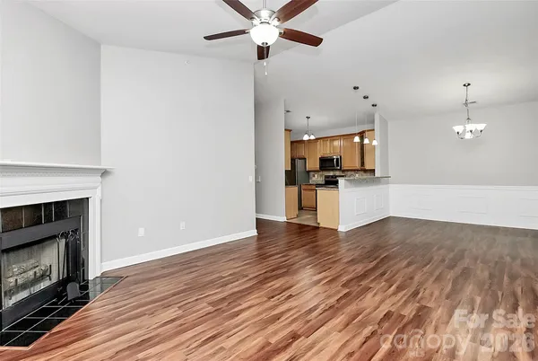 a view of empty room with wooden floor and fireplace