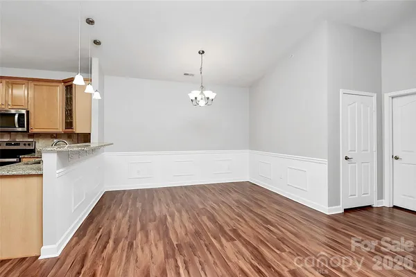 a view of a room with wooden floor and chandelier