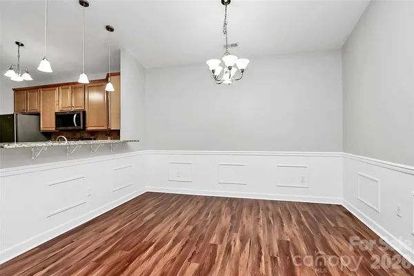 a view of a kitchen with a dishwasher a microwave oven and a wooden floor
