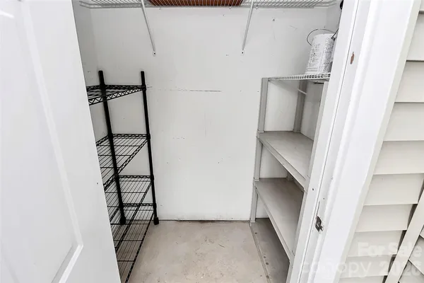 a view of staircase with white walls and empty racks