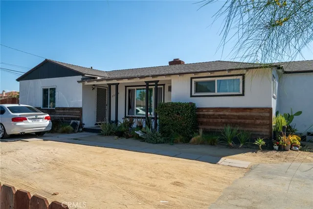 a view of house and yard with car parked