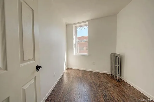 a view of a livingroom with wooden floor and a window