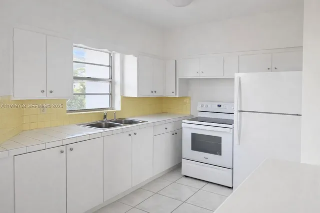 a kitchen with white cabinets and white appliances