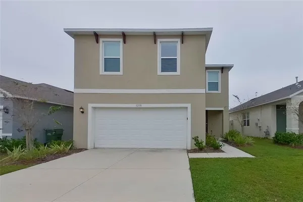 a front view of house with yard and garage
