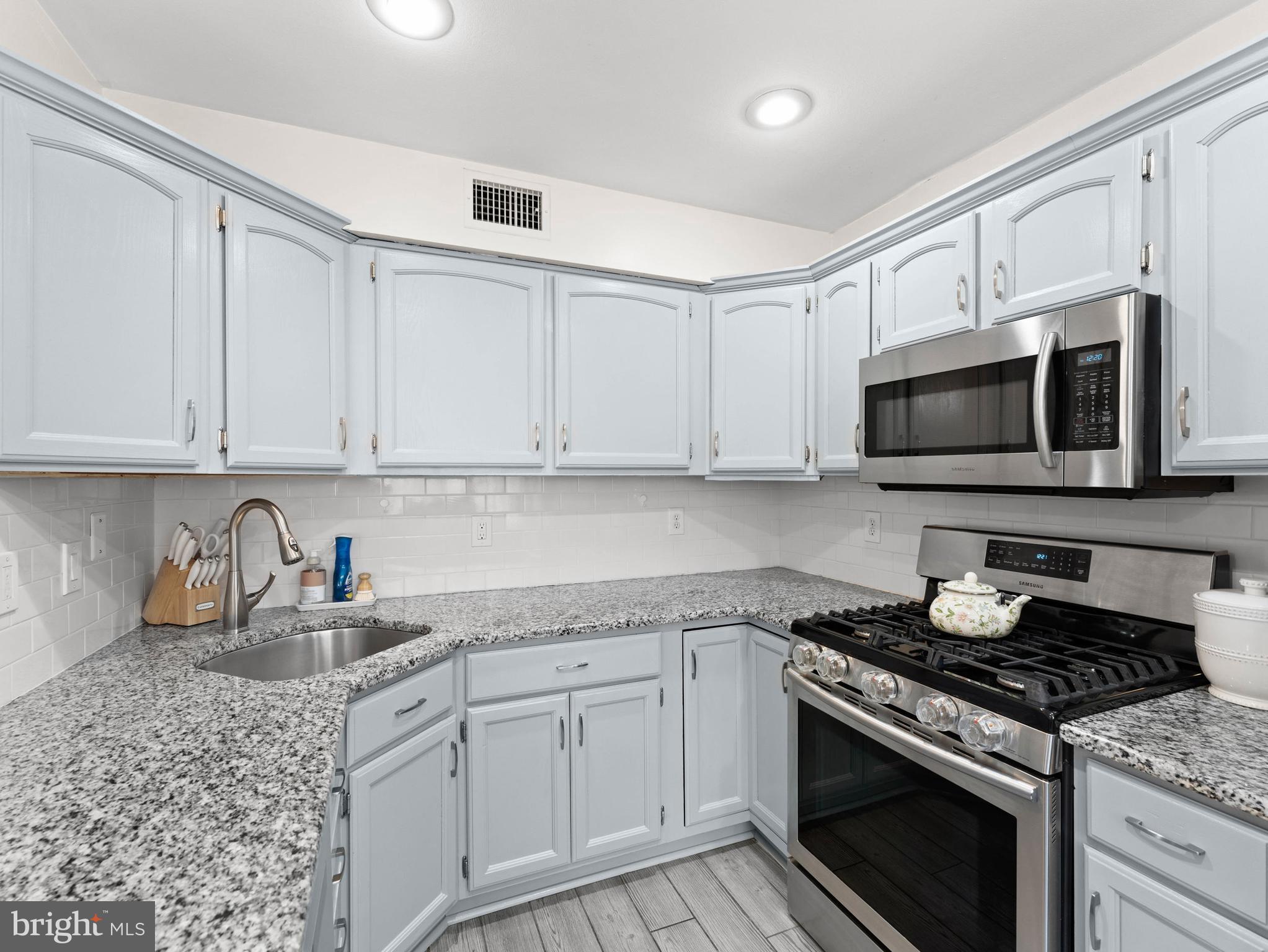 10839 Rayland Road Philadelphia, PA 19154 - Photo 11 of 30 a kitchen with granite countertop white cabinets and stainless steel appliances