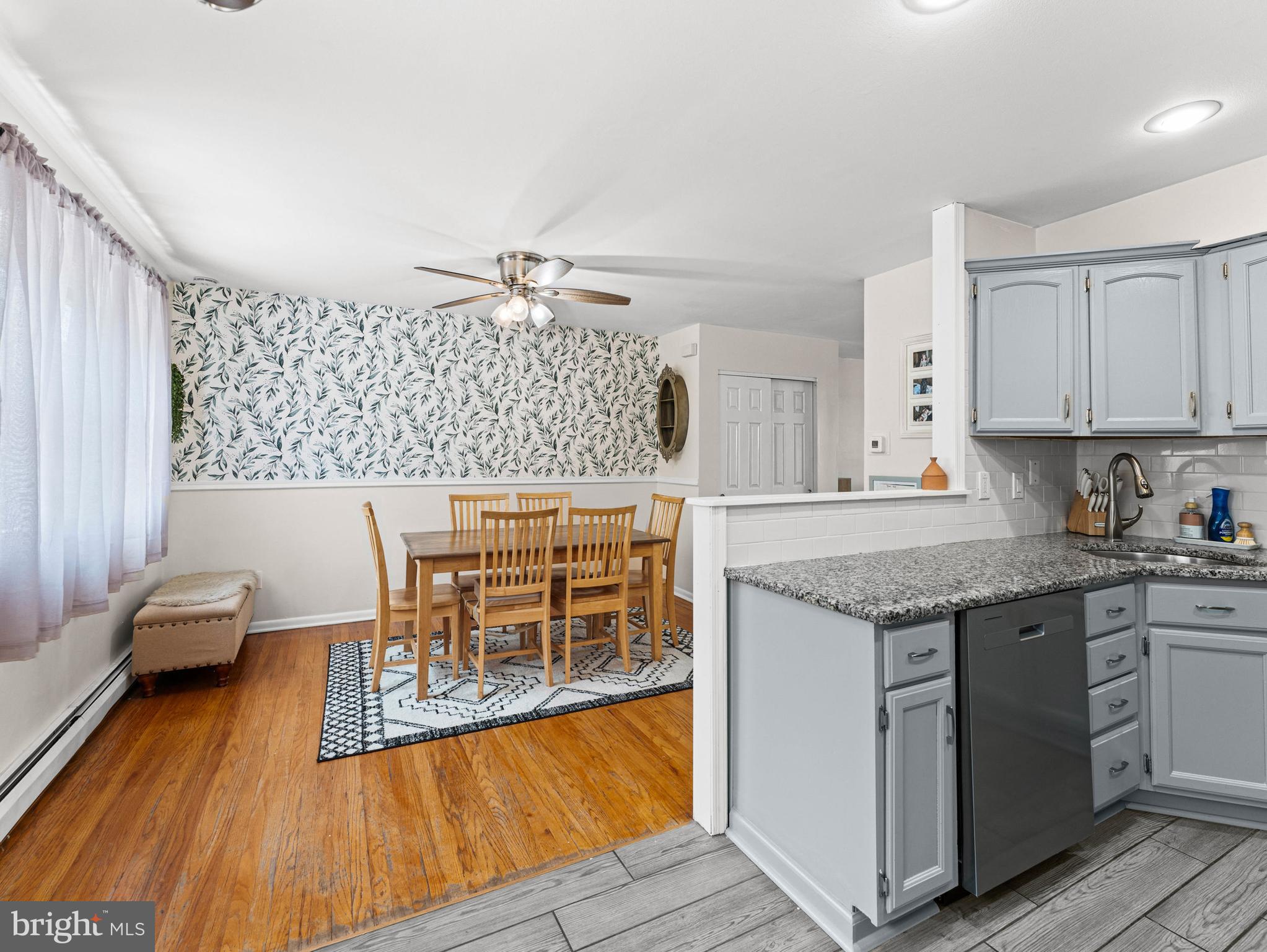 10839 Rayland Road Philadelphia, PA 19154 - Photo 9 of 30 a kitchen with granite countertop a stove a sink and white cabinets with wooden floor