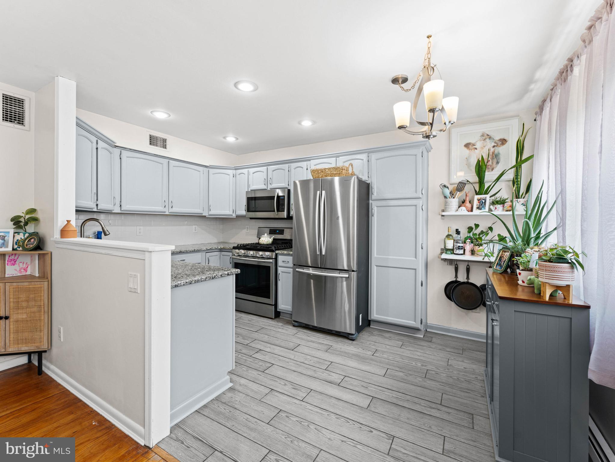10839 Rayland Road Philadelphia, PA 19154 - Photo 10 of 30 a kitchen view with stainless steel appliances a refrigerator a sink a stove a chimney a refrigerator and cabinets